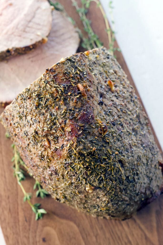 Sliced roast beef roast on a wood cutting board.