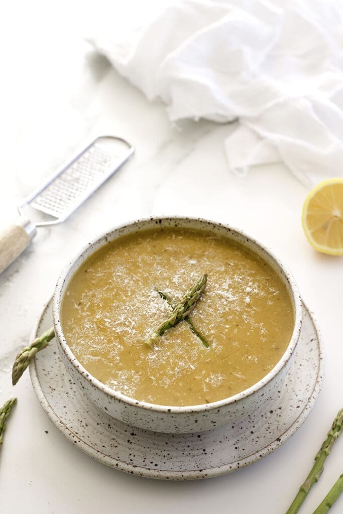The bowl of asparagus soup recipes has fresh asparagus tips.
