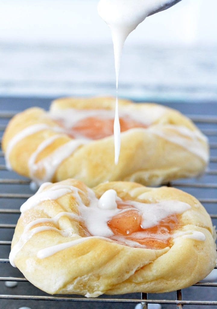 Apple Danish with powdered sugar glaze being drizzled on top.