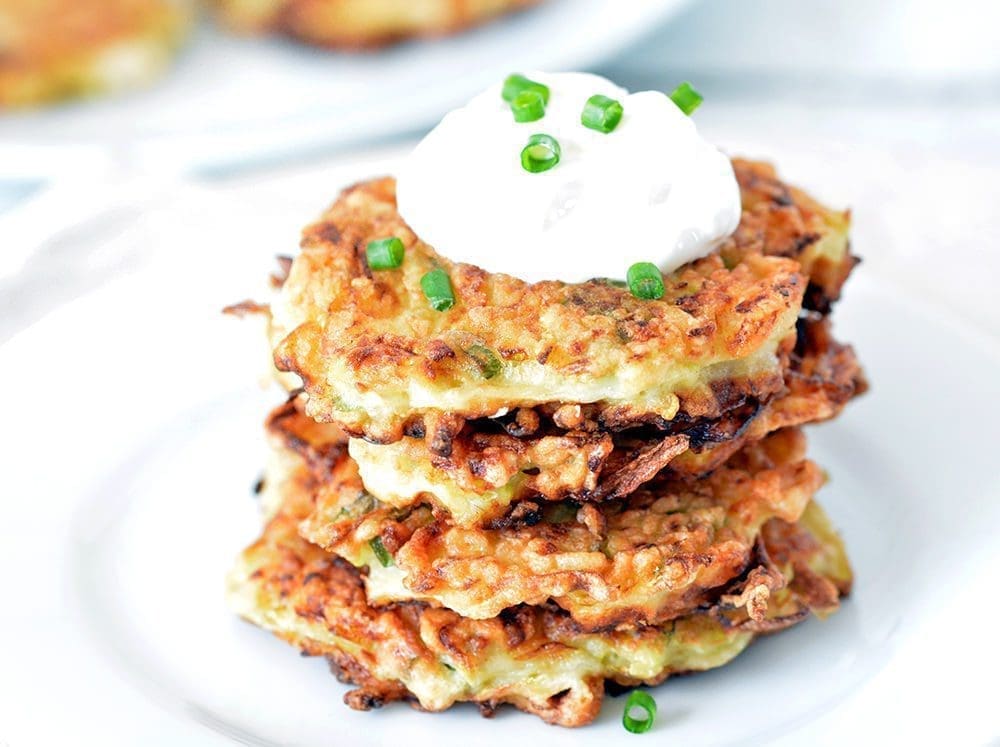 Zucchini Cakes stacked on a white plate.