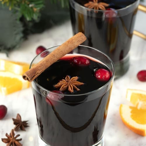 Glass of Mulled Wine with cinnamon stick and cranberries.