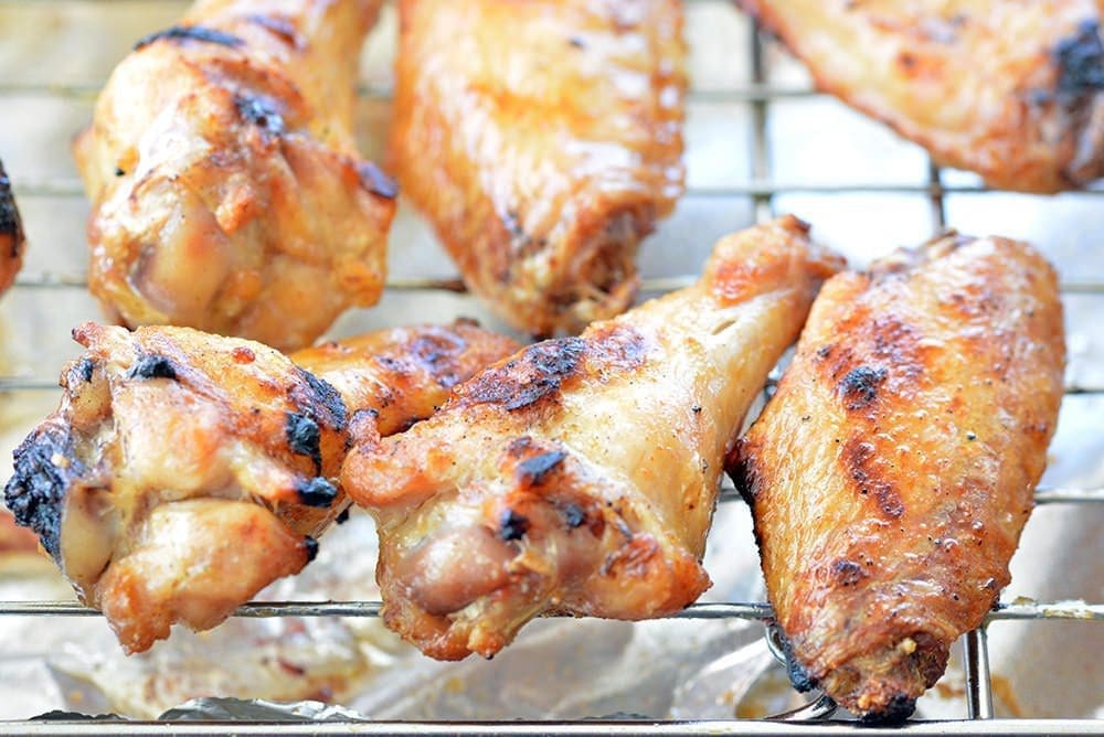 Cooked chicken wings on a wire rack.