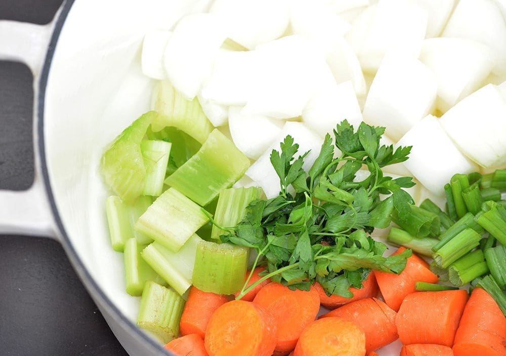 cut vegetables in a cream dutch oven.