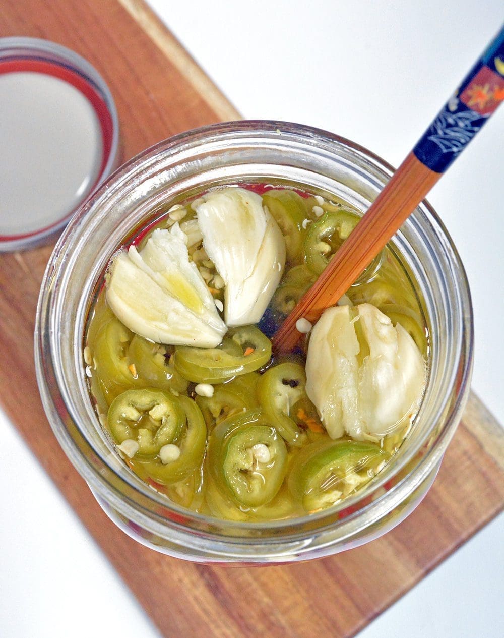 Pickled Peppers with a chop stick out the top.