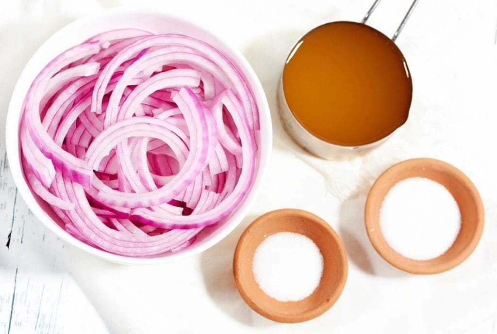 The ingredients to make pickled red onions: onions, salt, sugar and vinegar.