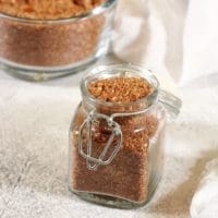 BBQ Dry Rub in a clear container. A large batch is in the background in a clear bowl.