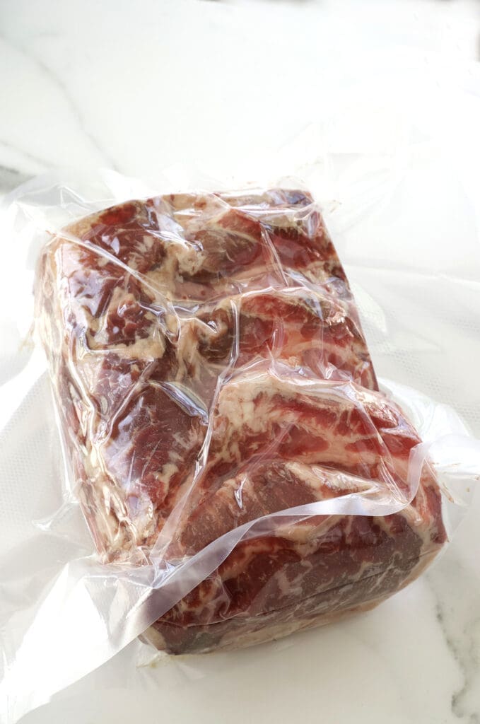 Uncooked prime rib in a vacuum vacuum bag.