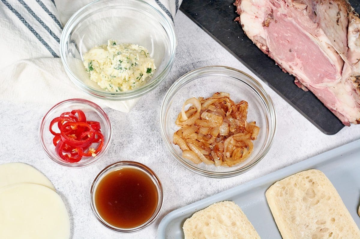 Prime Rib Sandwich Ingredients - leftover prime rib, bread, au jus, onions, garlic butter, peppers and cheese.