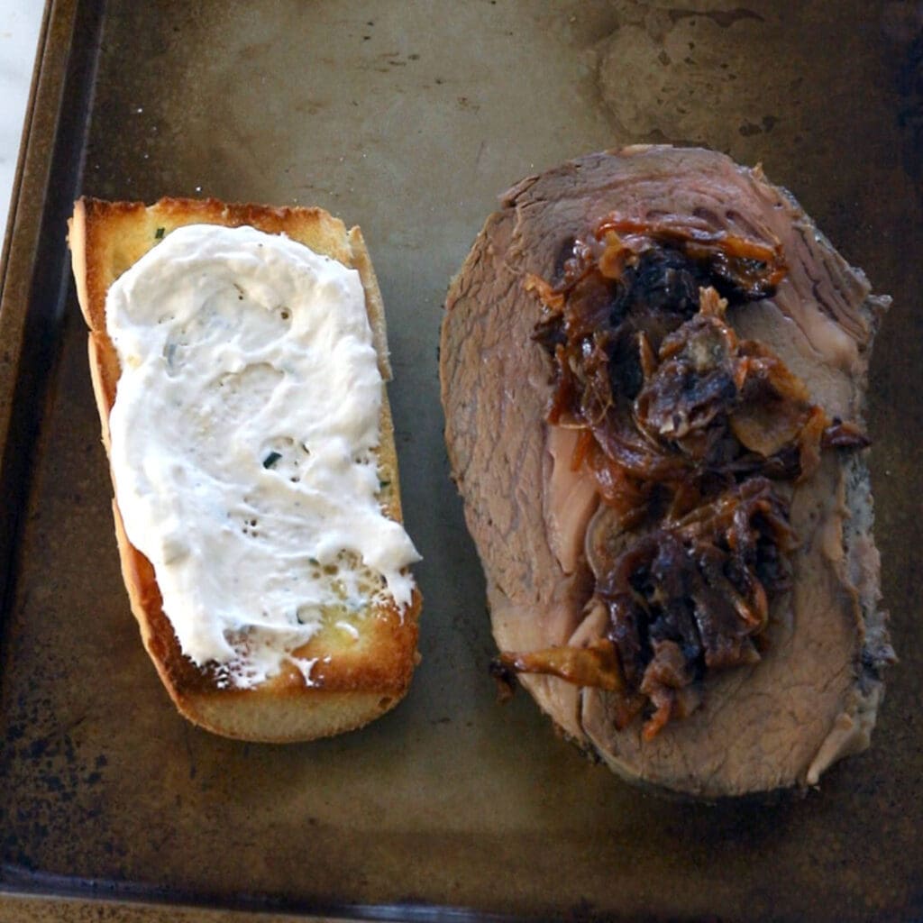 Two pieces of bread topped with horseradish sauce and beef.