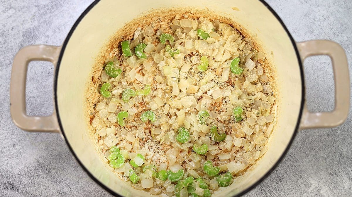 Cream dutch oven with flour, celery and onions mixed in.