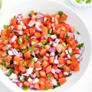 Pico de Gallo in a white bowl surrounded by the individual ingredients.