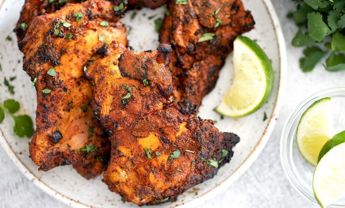 Speckled plate of grilled pollo asado chicken.