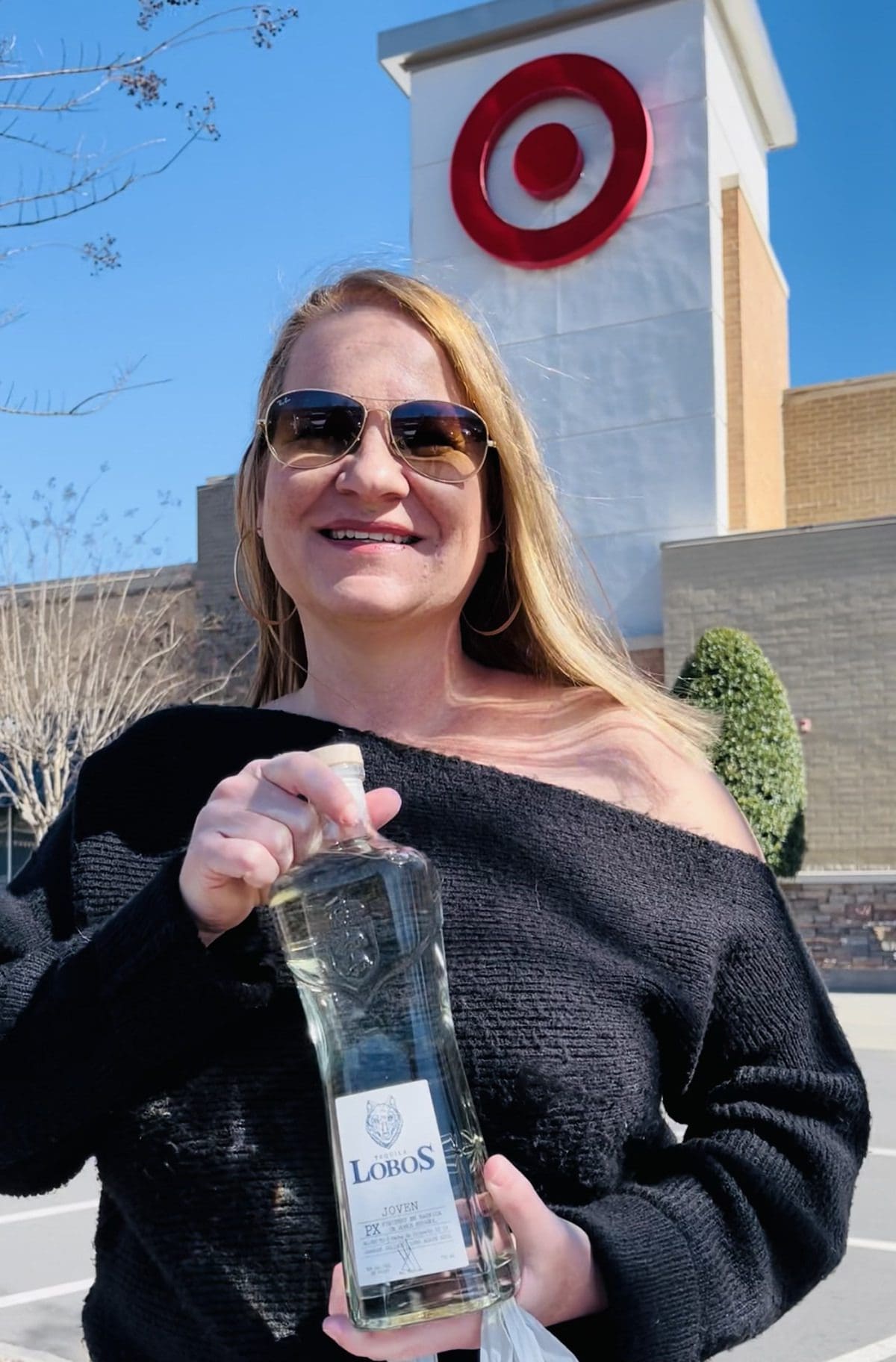 Blog owner holding a bottle of Lobos Tequila in front of the Target logo.
