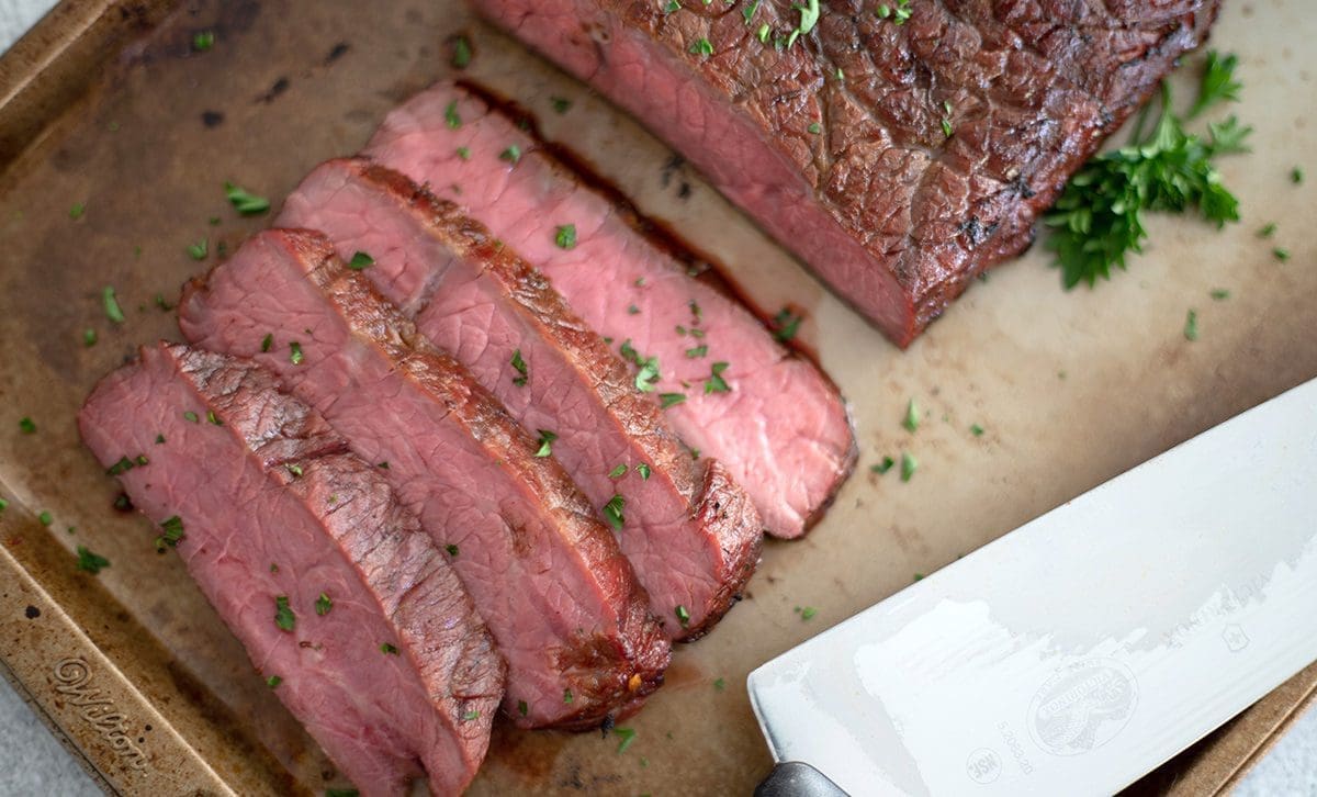 Sliced beef on a gold baking sheet.