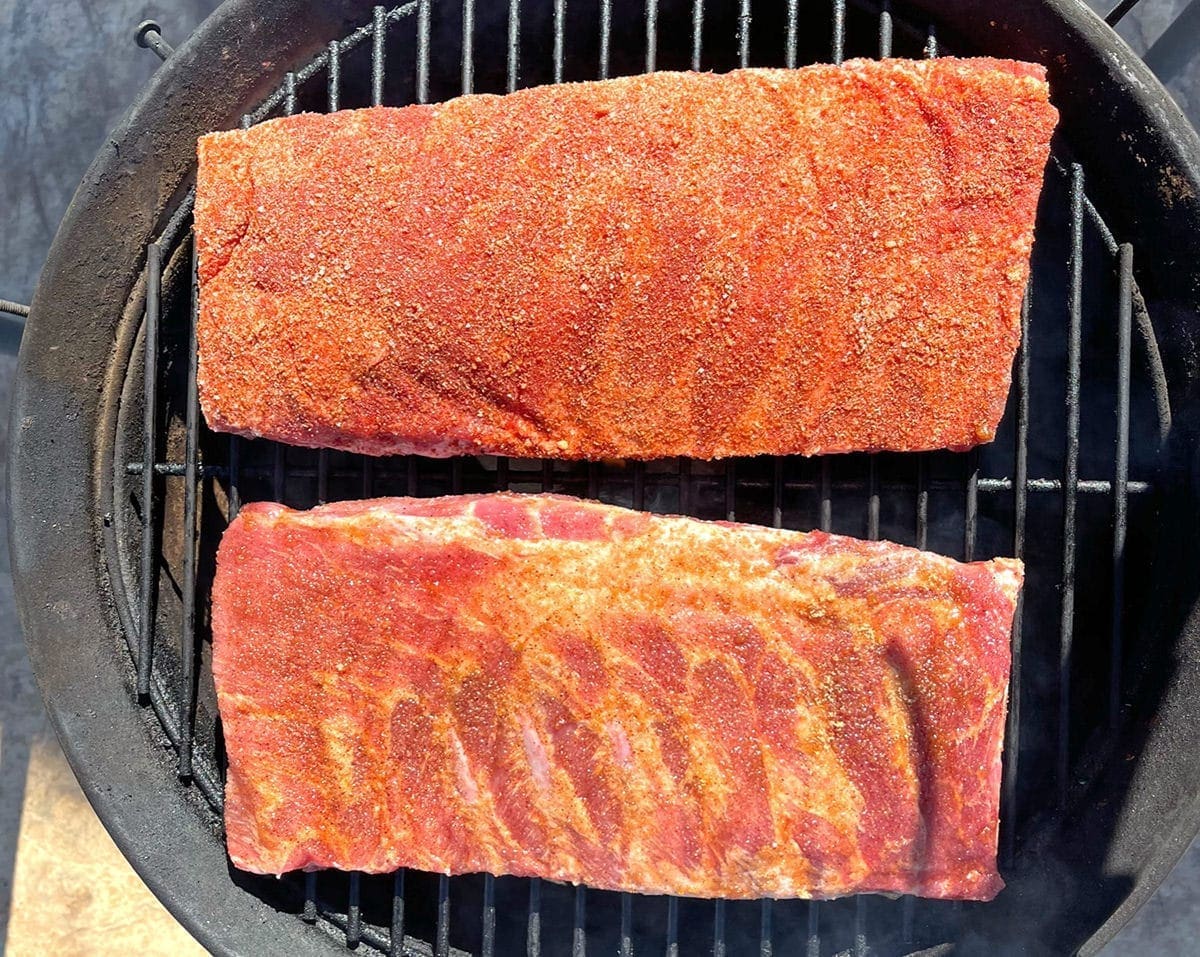 Two rib racks on a grill grate.