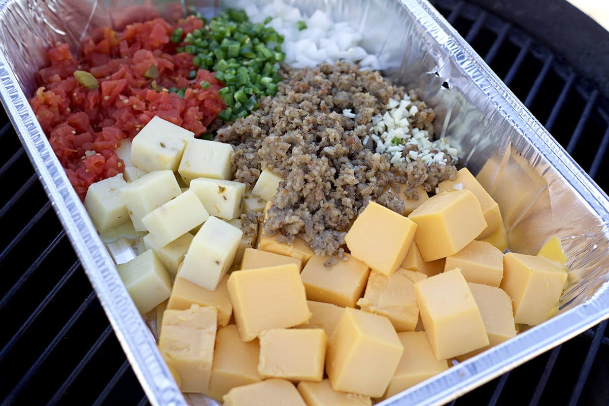 Ingredients to make smoked queso in a foil pan.