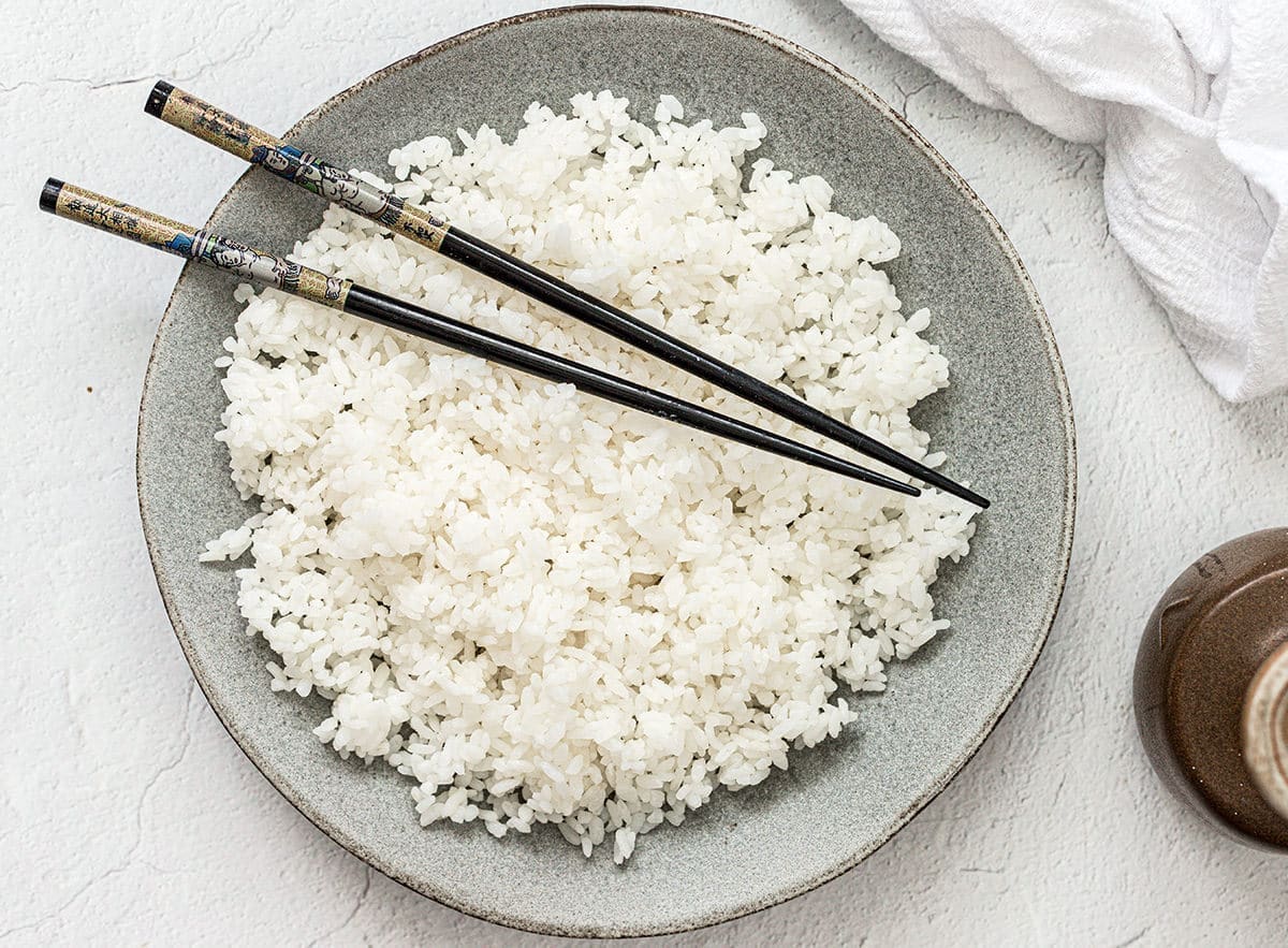 Plate of sushi rice with chop sticks.