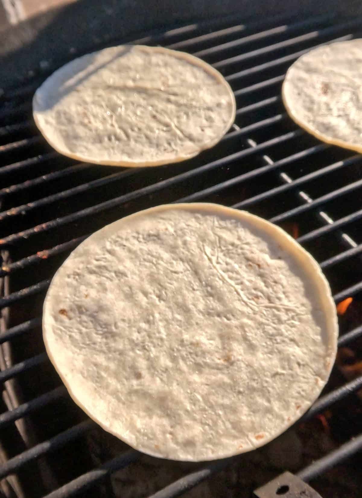 Corn tortillas on a grill.