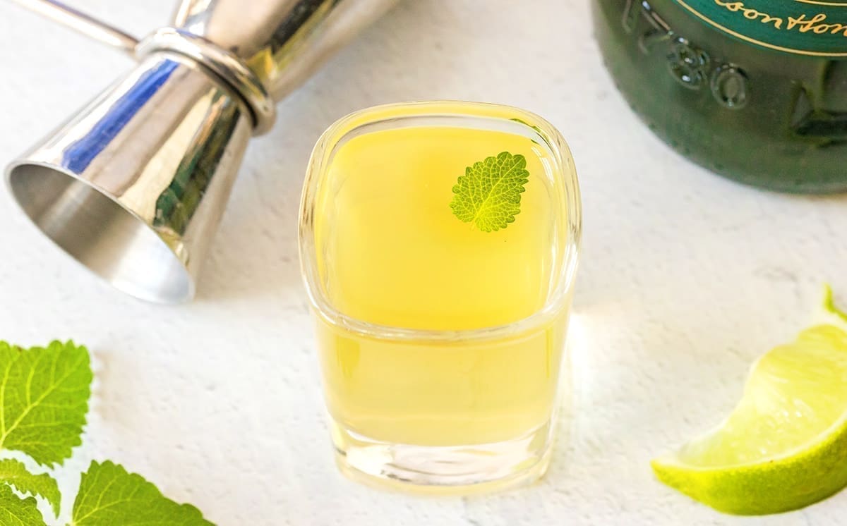 Green tea shot with a mint leaf garnish.