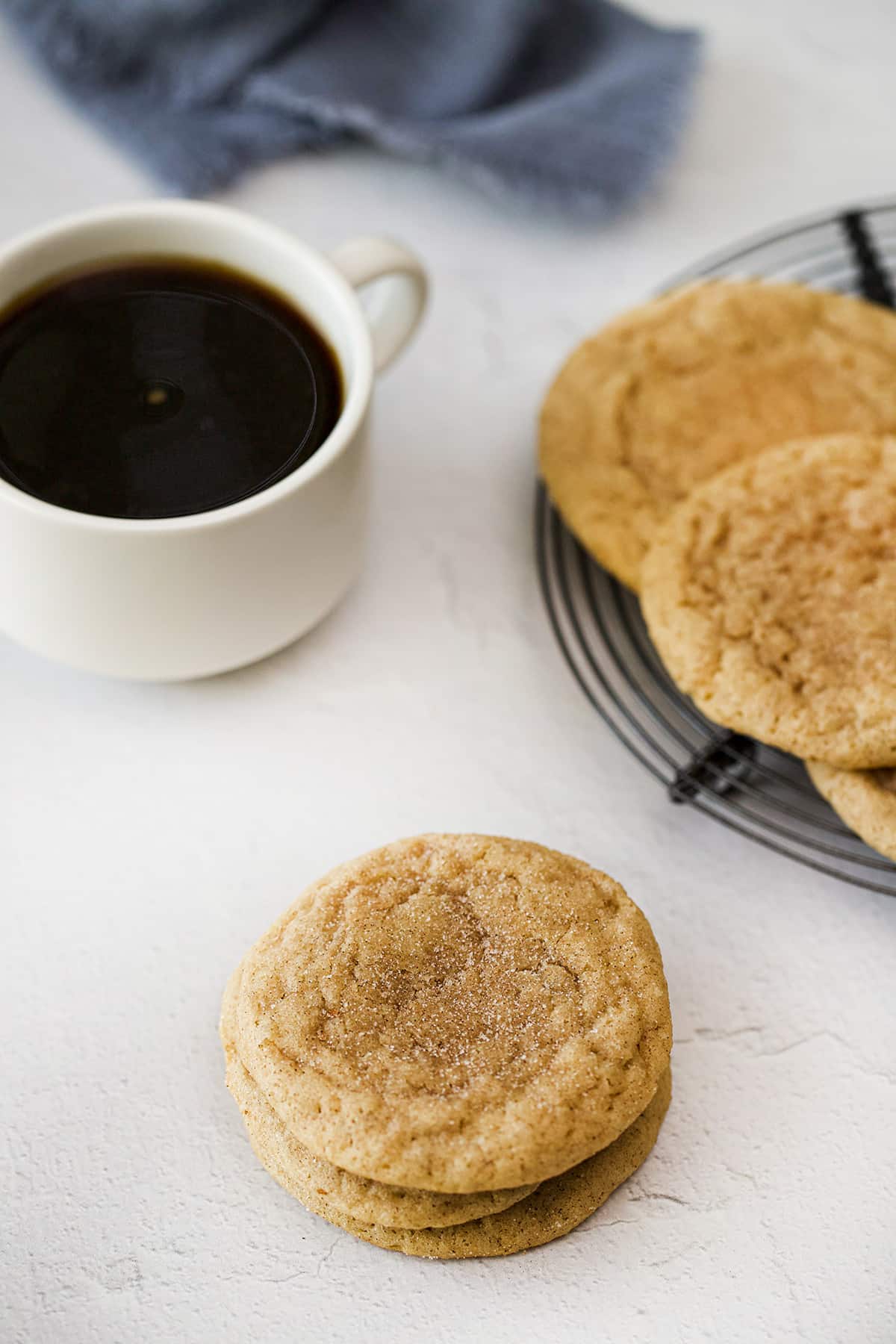 Stacked cookies by a cup of coffee.