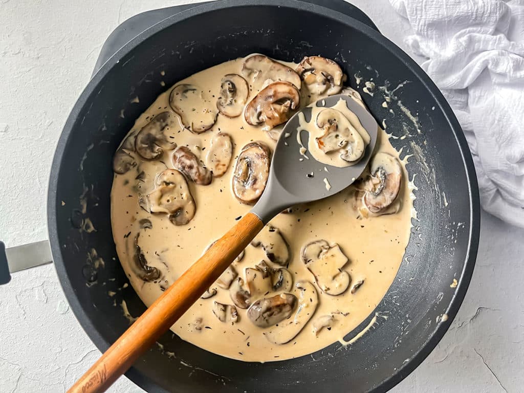 Mushroom cream sauce in a black frying pan.