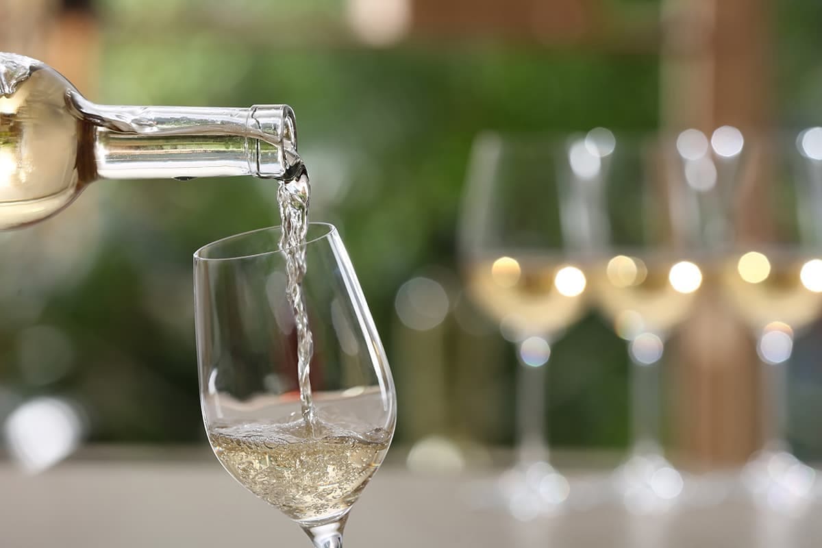 white wine being poured into a wine glass.
