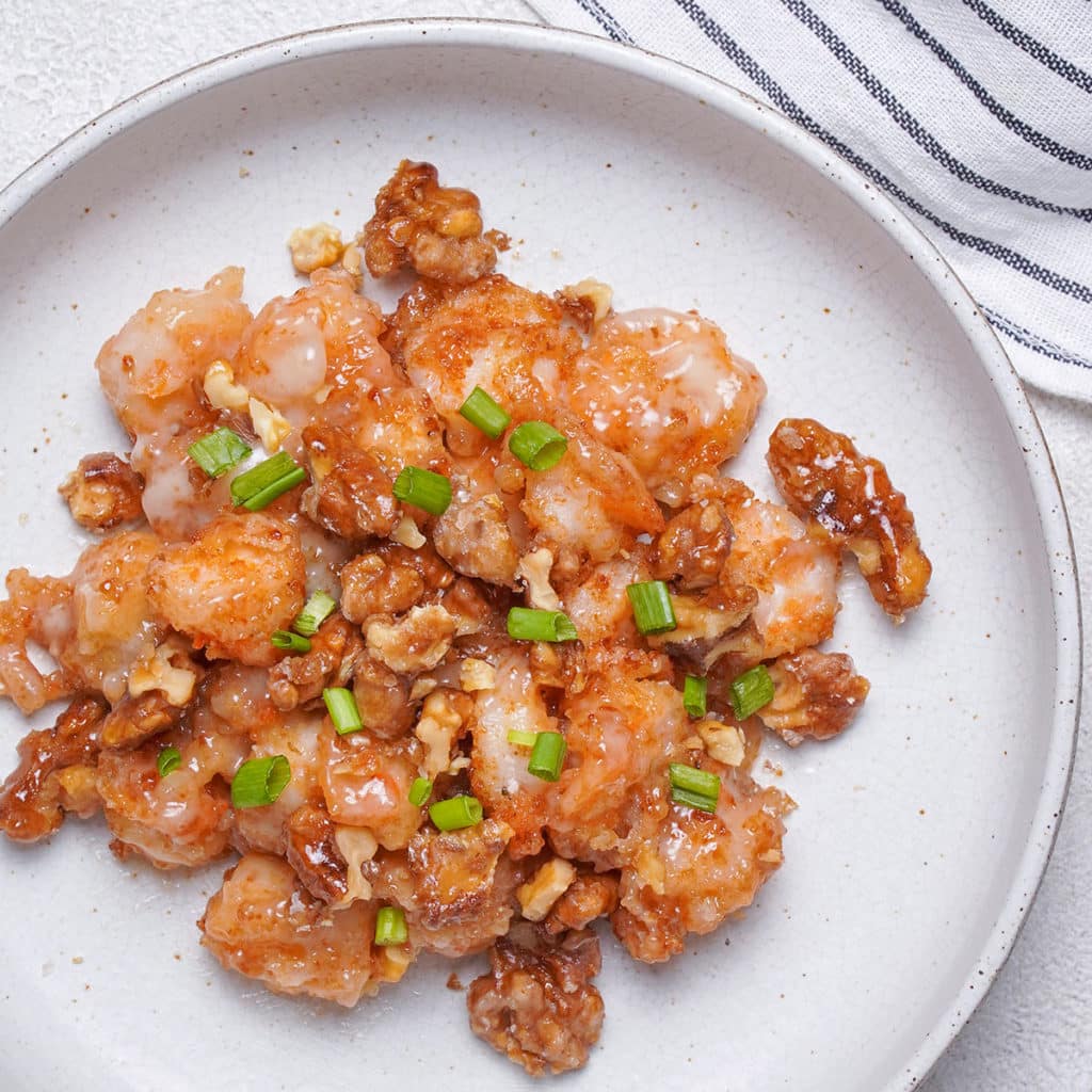 Honey walnut shrimp on a flat white plate.