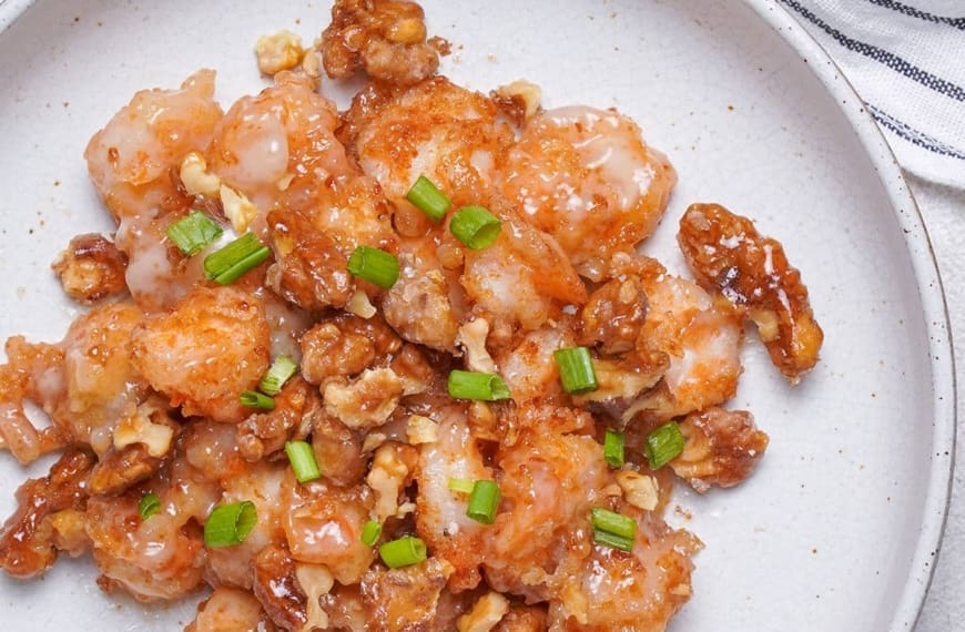 Honey walnut shrimp on a flat white plate.