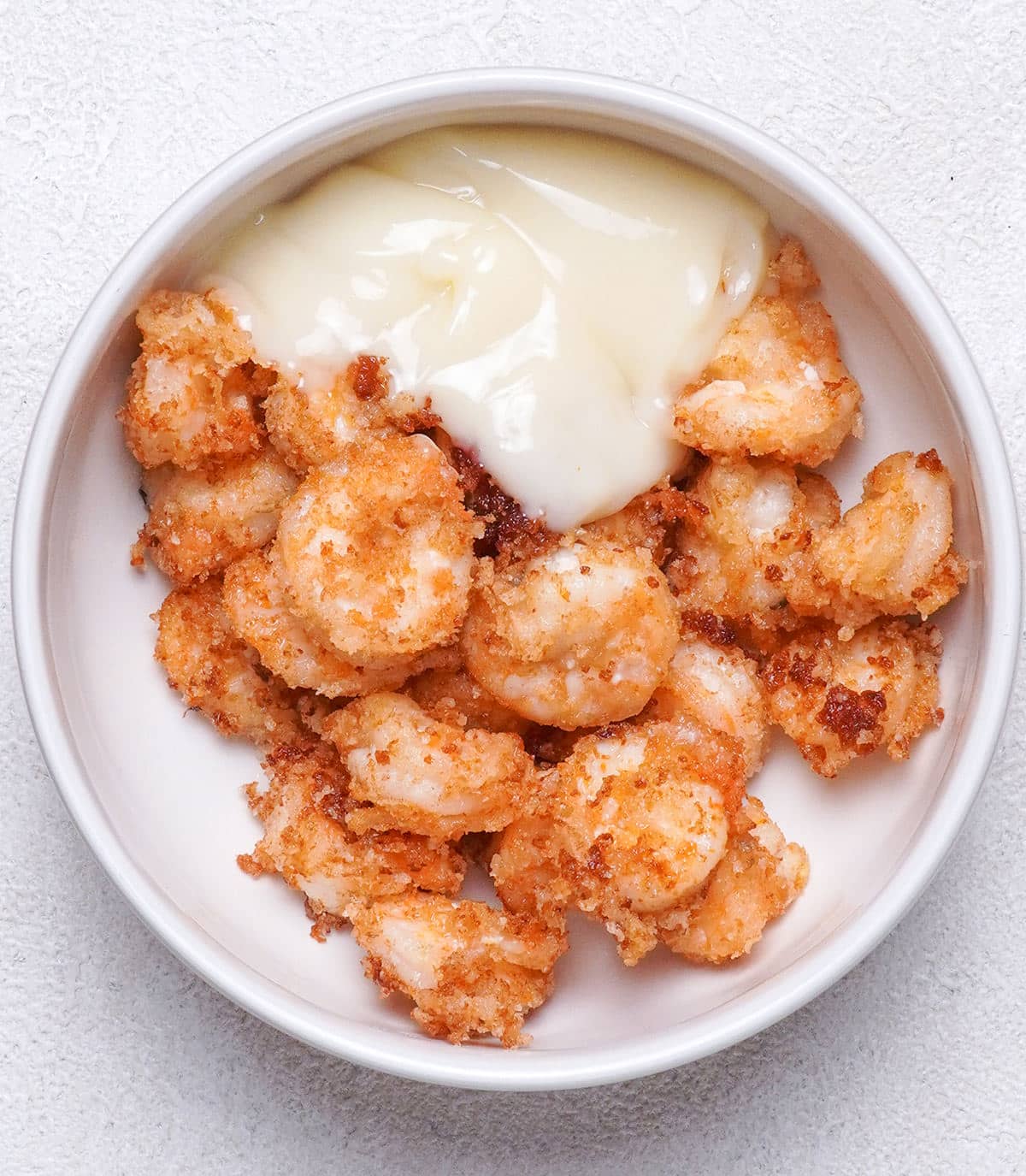 Fried seafood coated with white sauce.