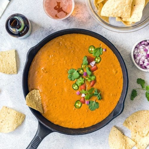 Chili Cheese dip in a cast iron skillet with chips.