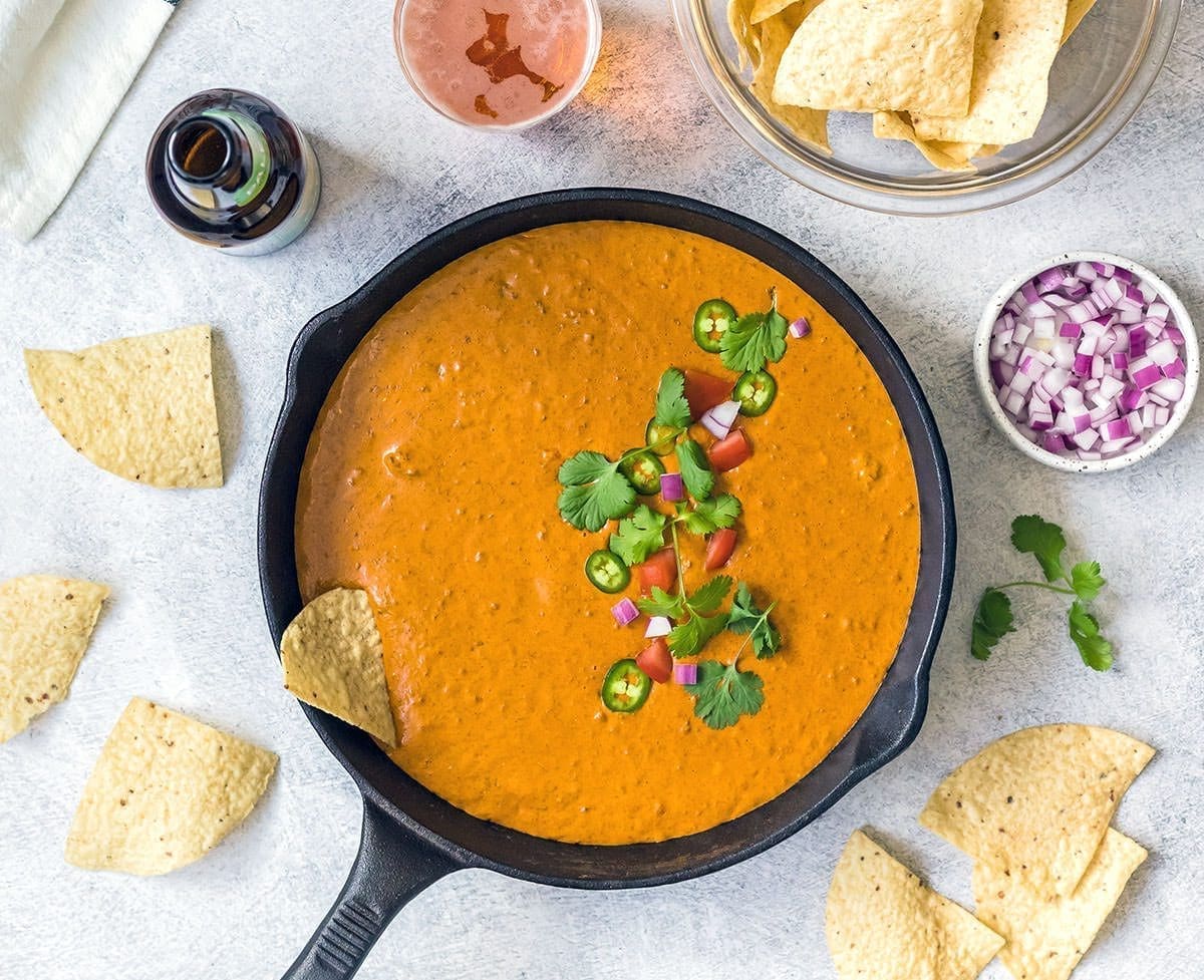 Chili Cheese dip in a cast iron skillet with chips.