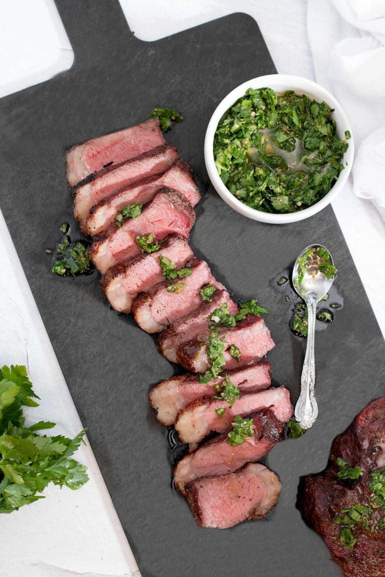 Picanha steak on a black cutting board.