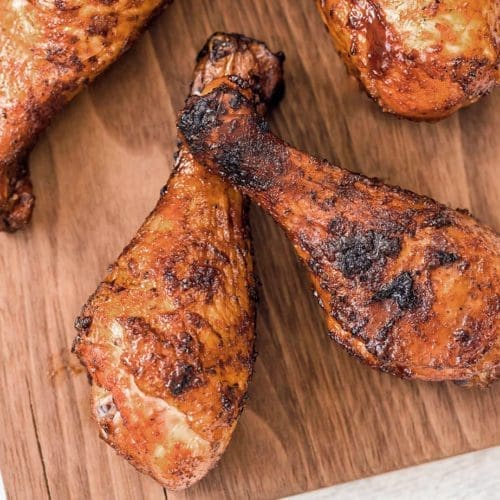Smoked chicken legs on a cutting board.