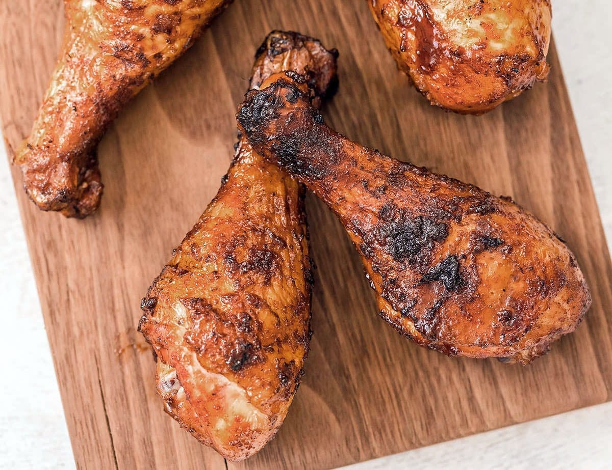 Smoked chicken legs on a cutting board.