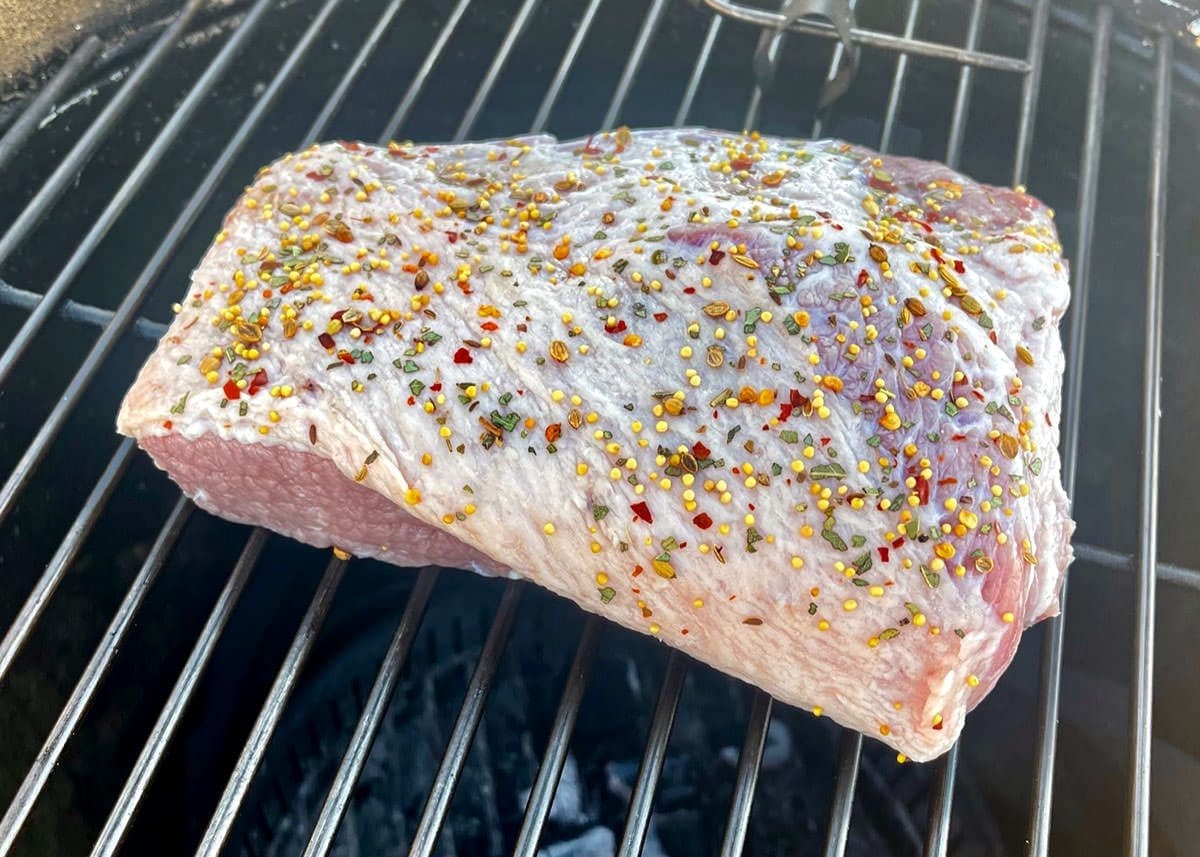 Uncooked corned beef brisket on a grill.
