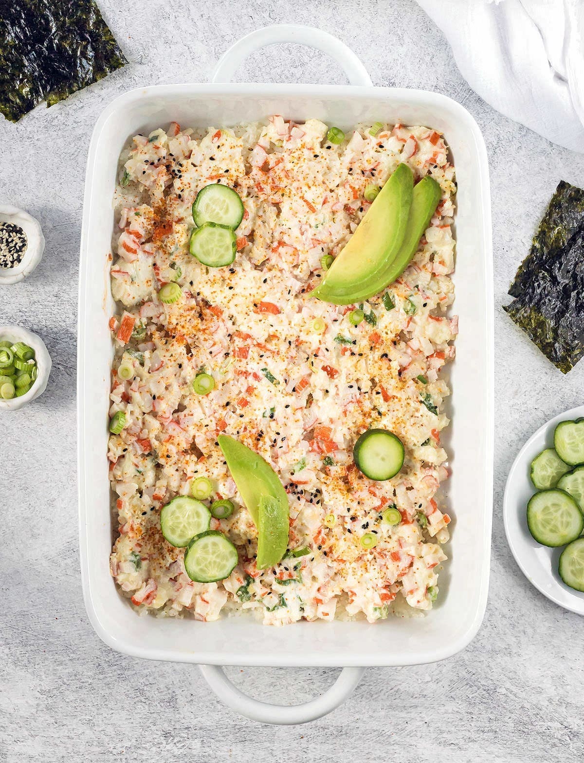 Baked sushi recipe in a white casserole dish.
