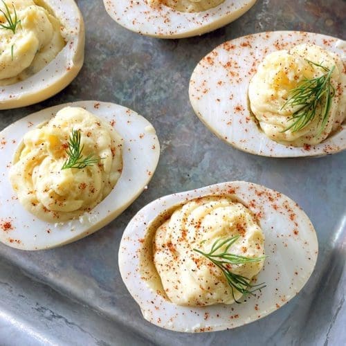 Smoked deviled eggs on a silver baking sheet.