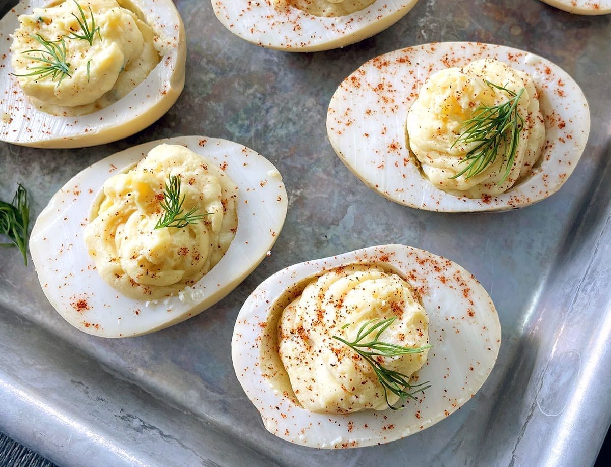 Smoked deviled eggs on a silver baking sheet.