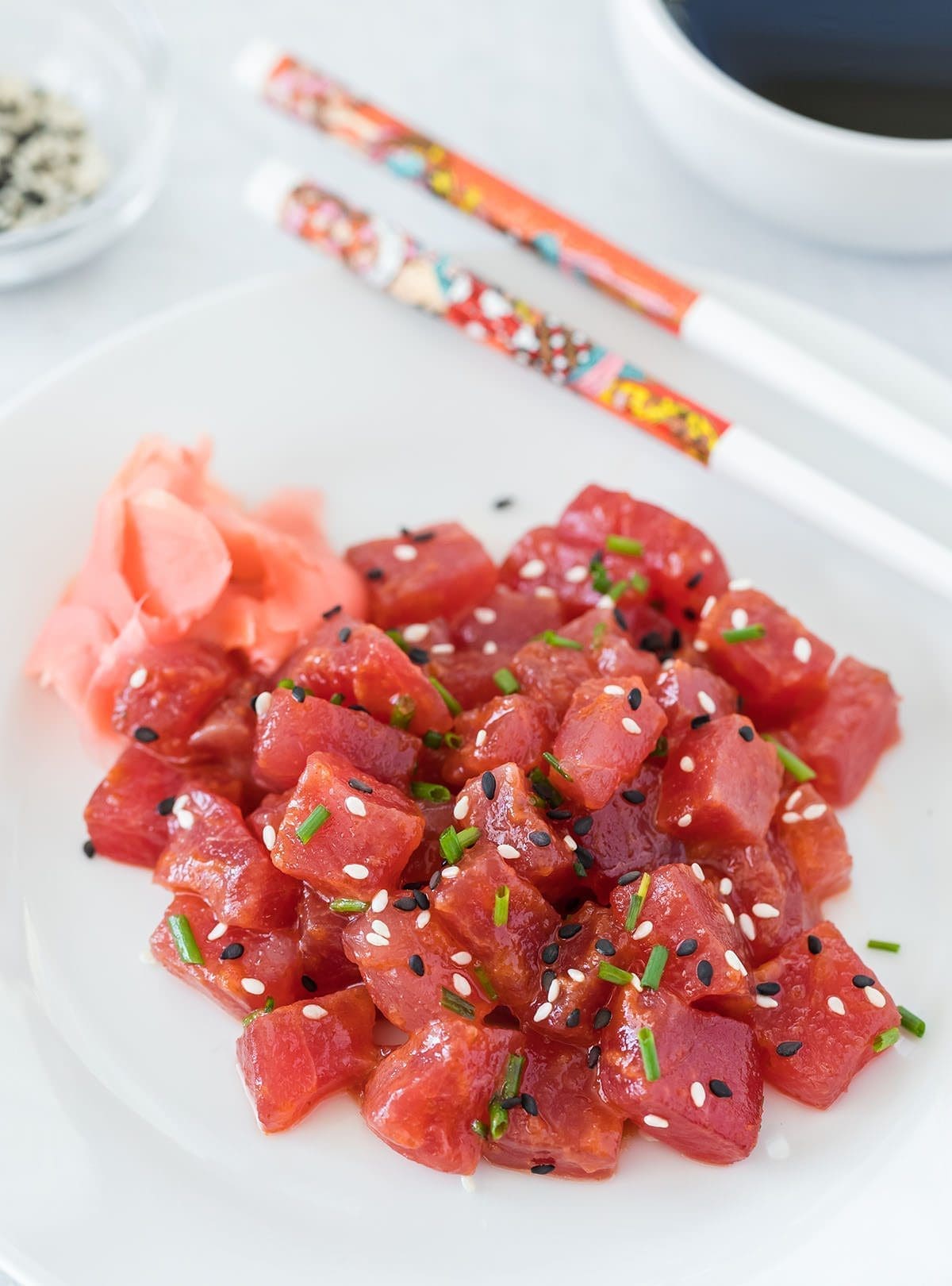 Spicy tuna on a white plate with chopsticks.