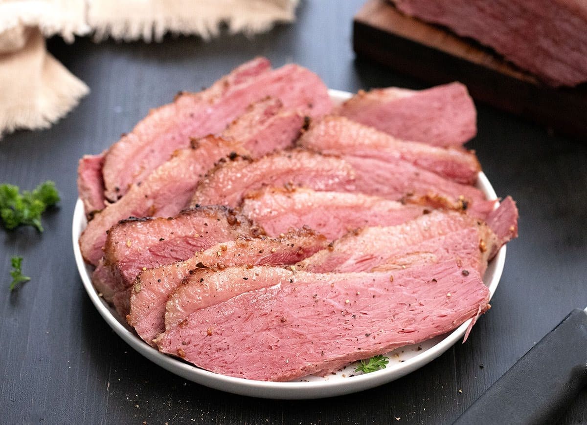 sliced corned beef on a white plate.