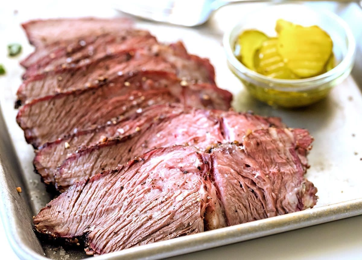 Sliced smoked chuck roast on a serving sheet.
