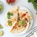 Carne asada quesadilla topped with guacamole and pico de gallo.