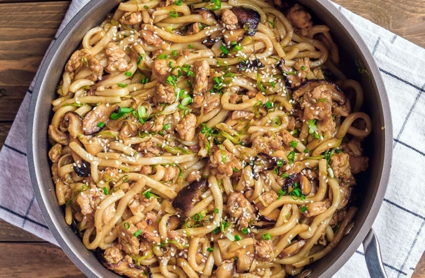 Skillet filled with yaki chicken udon.