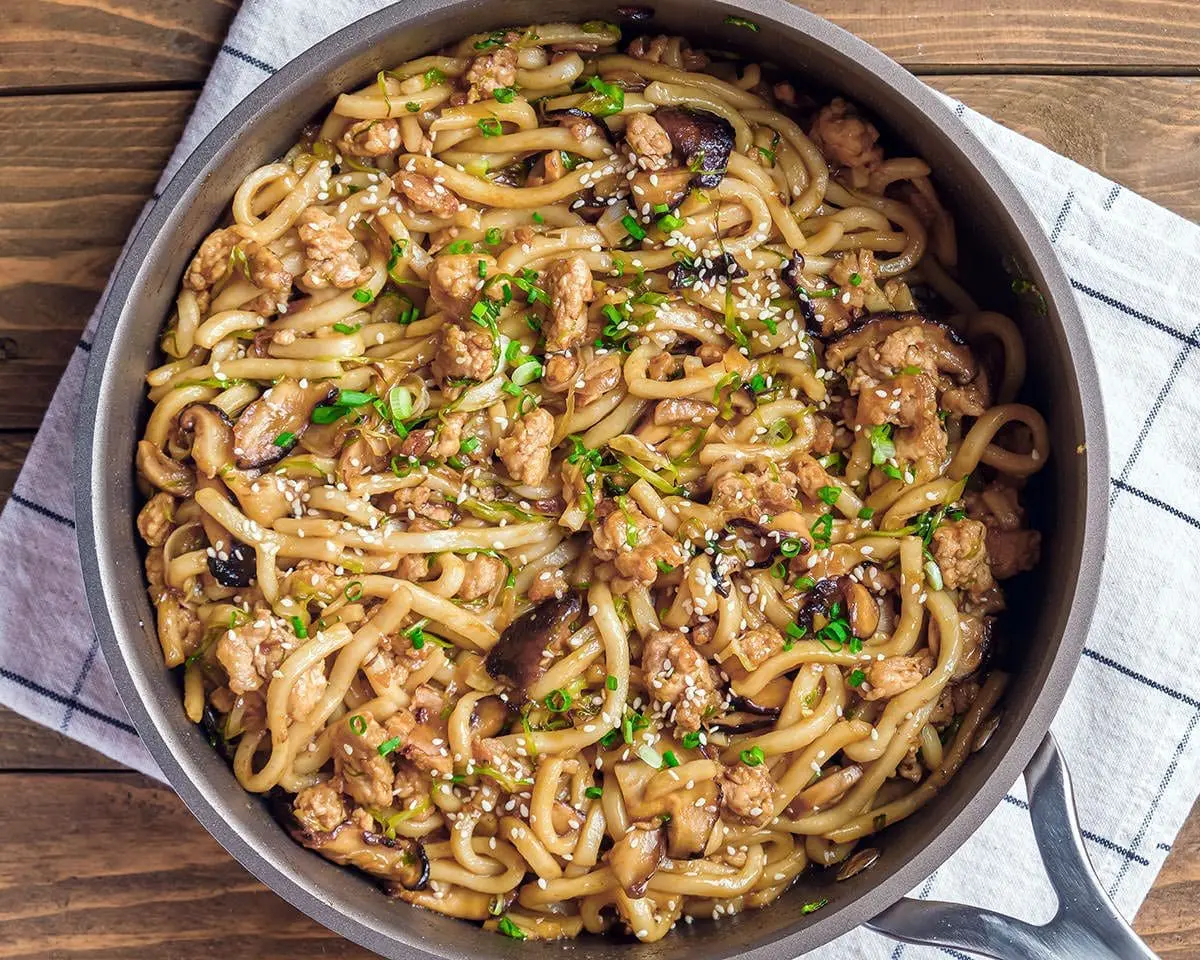 Skillet filled with yaki chicken udon.