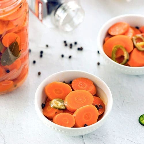 mexican pickled carrots and jalapenos in white bowls.