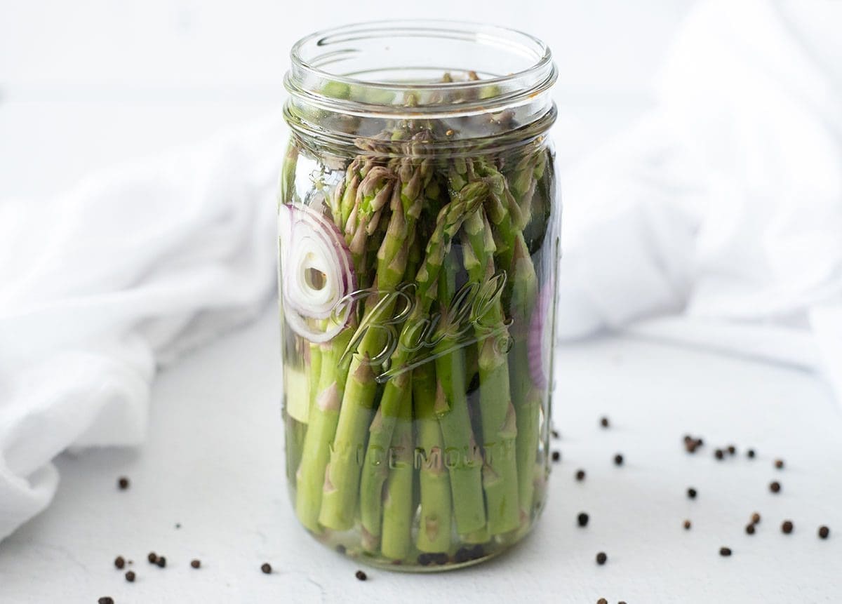 Glass jar filled with pickled asparagus.