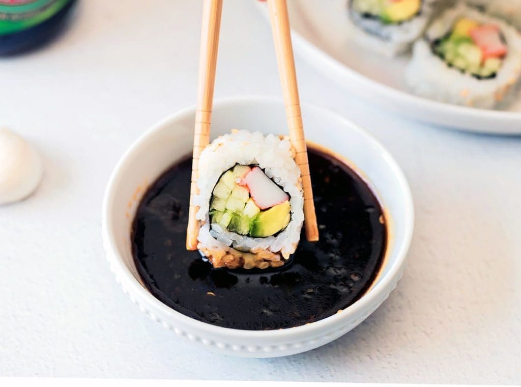 Sushi being dipping in a bowl of Sweet Soy Glaze.