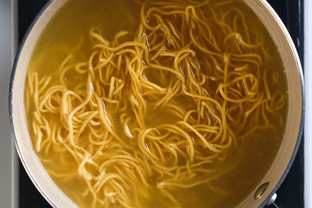 Noodles cooking in a pot of water.