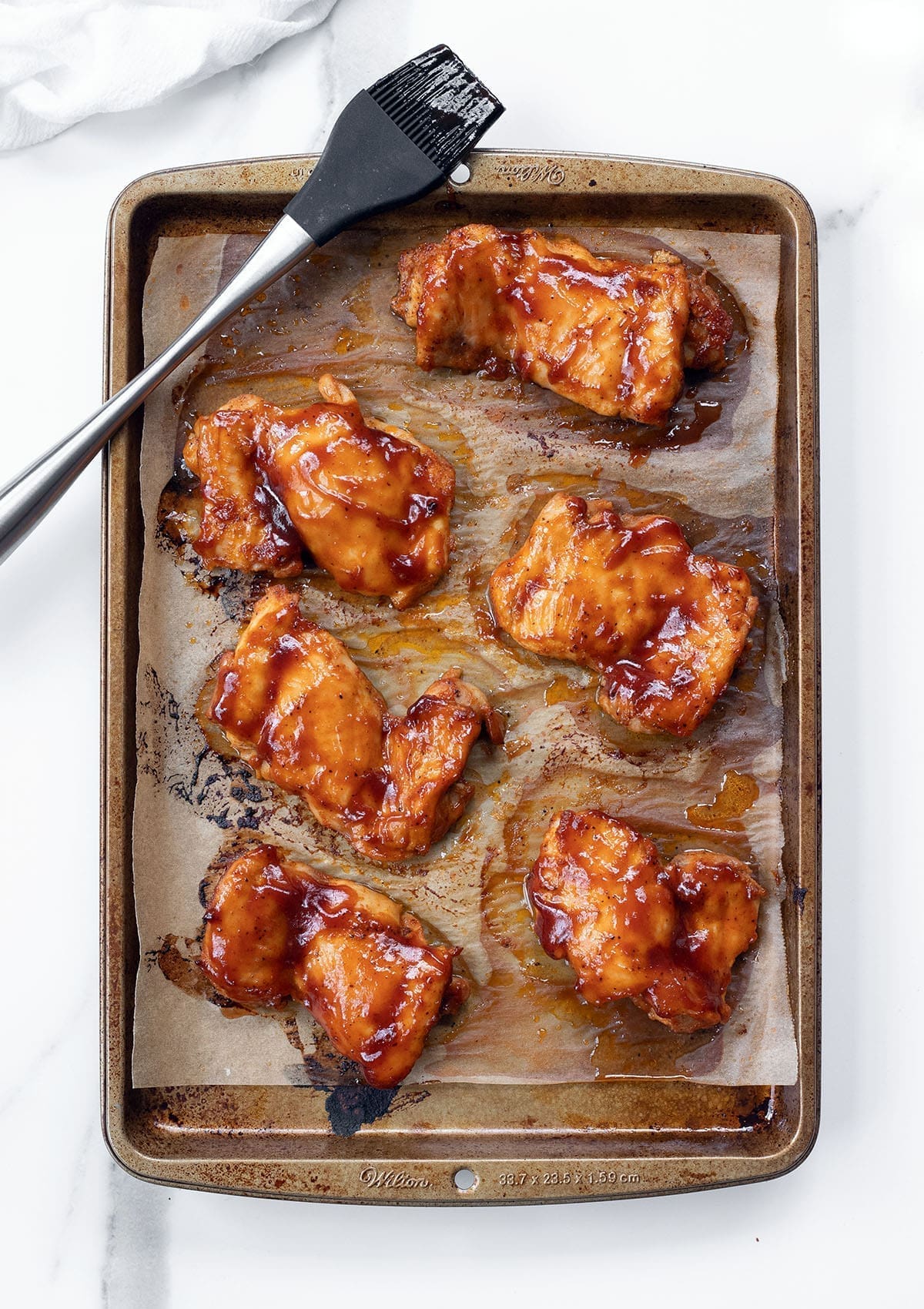 BBQ baked chicken on a baking sheet.