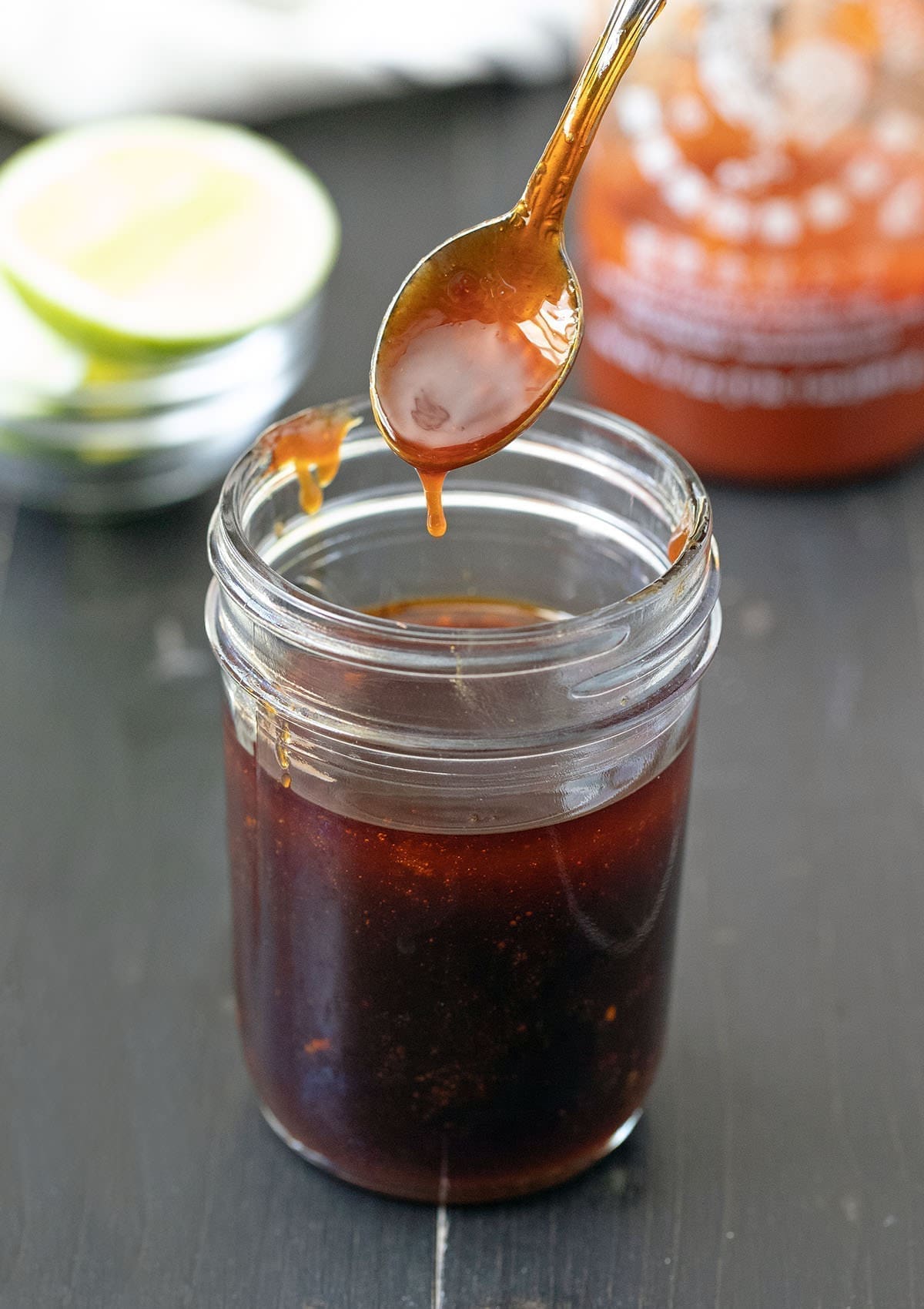 Spoon dipped in Honey Sriracha Sauce.